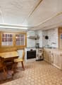 kitchen with dining area, wooden furniture, white appliances, tiled floor, wooden walls, large windows