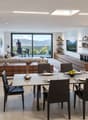 Dining room with dining table and chairs, white walls, balcony, living room with couch and coffee table, glass doors to the balcony, mountain view, pictures on the wall