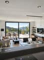 open space with living and dining area, large windows, grey sofa, coffee table, TV