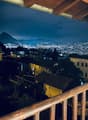 House in neighborhood, balcony, distant mountain and city lights, night view