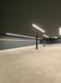 empty parking room, gray walls, white floor, fluorescent lights
