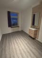 bathroom with wooden flooring, window with curtain, mirror, wooden sink, radiator, ceiling lights
