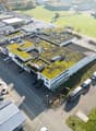 multi-storey building, green rooftop, multiple parking spots, various vehicles