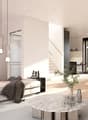 living room with white walls, grey couch, white center table, open to dining room with windows and view to outside