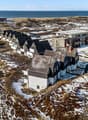 Aerial view of a row of houses with snow on the ground, near the sea
