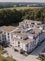 2 story apartment building, white exterior, multiple windows, parking lot, multiple cars parked