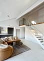 modern design, white tiles, large couch, coffee table, glass staircase, glass doors