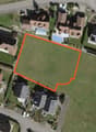 Plot of land with an area of 1,000 square meters, surrounded by houses and greenery.