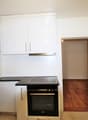 modern kitchen, white cabinets, black countertops, stainless steel appliances, sink, dishwasher, oven