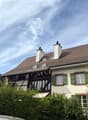 2 story house, brown roof, white walls, green shutters, 2 chimneys, balcony