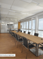 conference room, long table, chairs, large windows, overhead lights