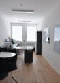 empty office with tables, chairs, computer, whiteboards, frames, wooden floor