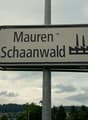 Street sign pointing to the direction of 'Mauren Schaanwald', located outdoors