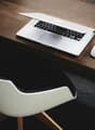 wooden desk, white chair, laptop, mouse