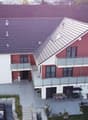 2 story house, red and white, 2 balconies, 2 cars parked, garden, patio