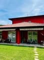 Red house, terrace, garden, patio, green grass, mountain in background