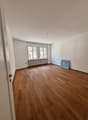 empty room, wooden floor, white walls, windows, radiator