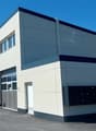 modern building, multiple garages, white exterior, glass windows, number 22 on the wall