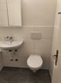 Bathroom with white sink, white toilet, white tiles, white cabinet, silver faucet, silver flush button