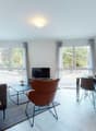 Living room and dinning area, hardwood floor, large windows, coffee table, sofa, chair, TV, desk