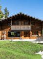 wooden chalet, gable roof, balcony, deer statue, stone wall, garage