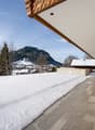 covered terrace with snow, stone flooring, mountains in background