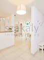 white walls, white tile flooring, white ceiling, white bench, white shelf, decorative items, hanging lamp, open door