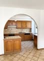 modern kitchen, wooden cabinets, tiled floor, sink, dishwasher, microwave, refrigerator