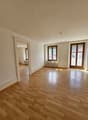 empty room, wooden floor, white walls, two windows, sliding doors, radiator