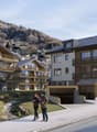 Modern multi-story buildings with balconies and terraces, raised ground floor entrance