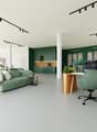 green walls, large green sofa, round table with office chair, dining room table and chairs, kitchen area with coffee machine