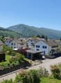 detached houses, residential neighborhood, detached garages, trees, mountainous background