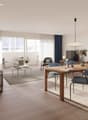 Open-concept living and dining area with large windows, hardwood floors, modern furniture including a wooden dining table with chairs, a sofa, and a coffee table. The room also features a balcony or terrace, artwork on the walls, and decorative accents th