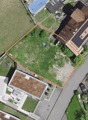 Aerial view of house and adjacent area. Plot with numbers on sides, house with solar panels on the roof.
