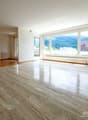 large room with marble flooring, white walls, sliding glass doors, large windows with view, underfloor heating