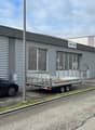 grey building with sign AMAVIS, 3 cars parked in front