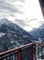 snowy mountains, clear sky, red and black railing, view of village