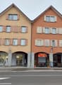 Apartment building with three floors, multiple windows, entrance, restaurant area