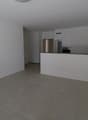 Empty room, tiled floor, kitchen, white walls and ceiling, cupboards, countertop