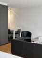 living room with sofa, armchairs, coffee table, desk, chairs, TV, lamp, tiled floor