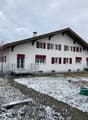 white house, red shutters, sloped roof, covered porch, metal railing, front garden, chimney