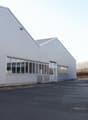 metal siding, large windows, adjacent smaller building, empty parking lot