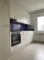 kitchen with white cabinets, blue backsplash, electric stove, oven, sink with faucet, tile flooring