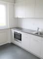 modern kitchen with white cabinets, stainless steel appliances, granite countertop, large window