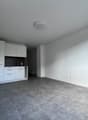 empty room with gray floors, white walls, built-in cabinets, and electrical outlets