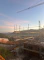 construction site with steel scaffolding, crane in the background, view of the mountains and horizon