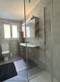 Bathroom with a toilet, sink, shower, and a window