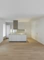 Open kitchen, white cabinets, wooden floor, white walls, central island, modern design