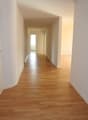 Empty hallway with wooden floors and white walls