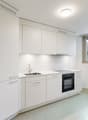 kitchen with modern design, white cabinets, sink, gas stove, oven, built-in dishwasher, under cabinet lighting, large window